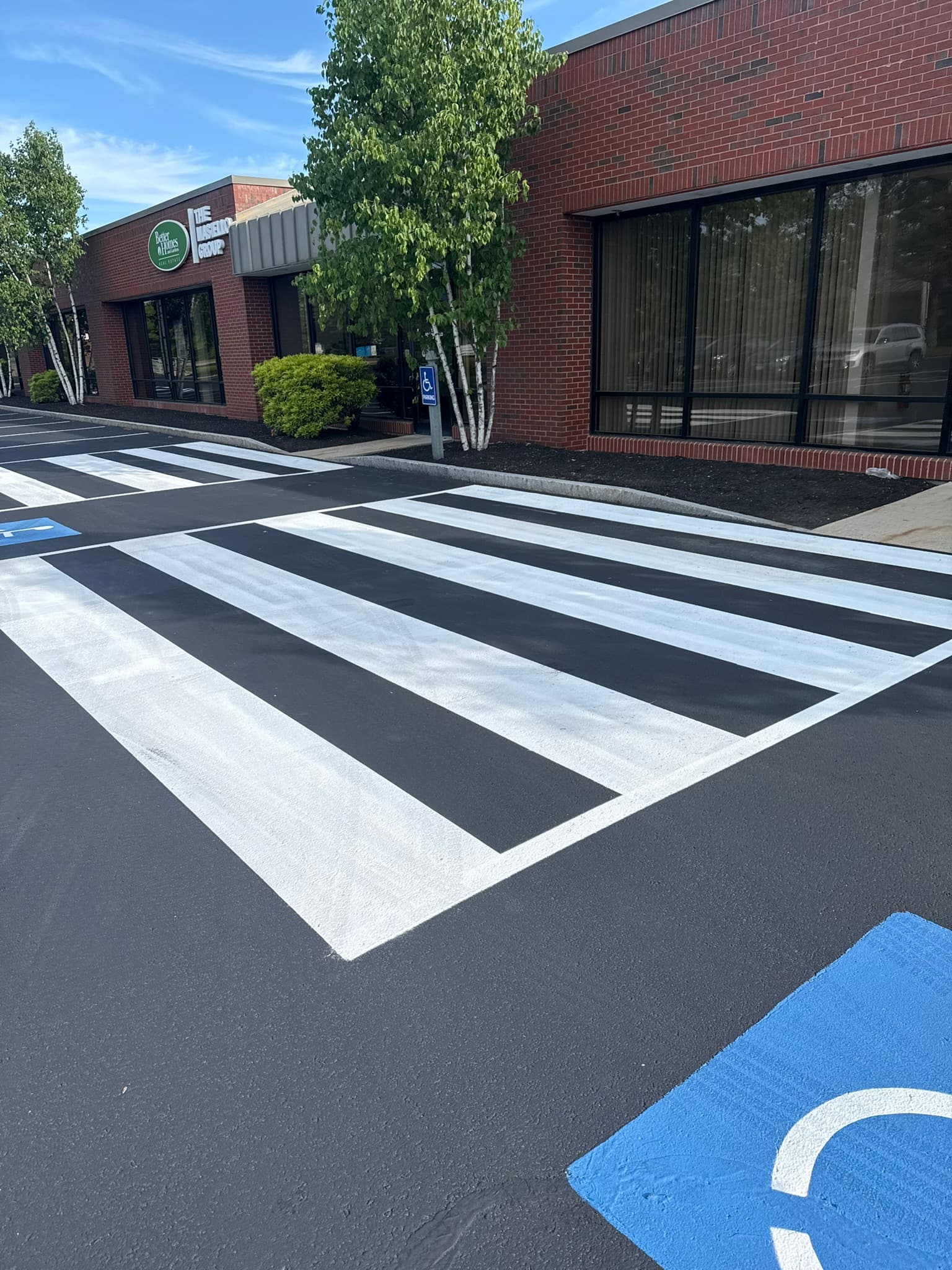 Freshly sealed lot with crosswalk striping and ADA-compliant accessible parking symbols
