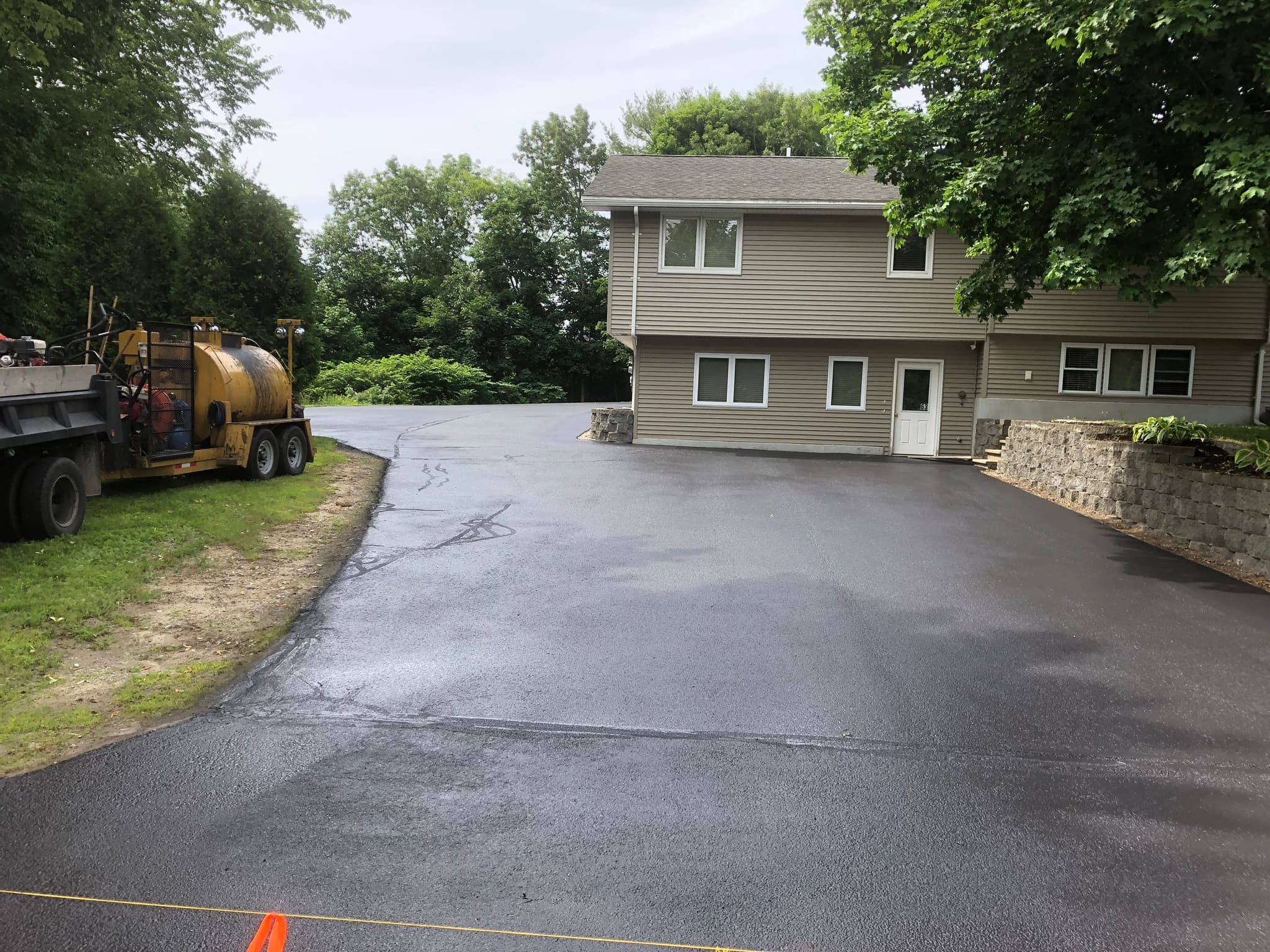 Raised ranch with double-wide driveway, freshly sealed, roped off to cure