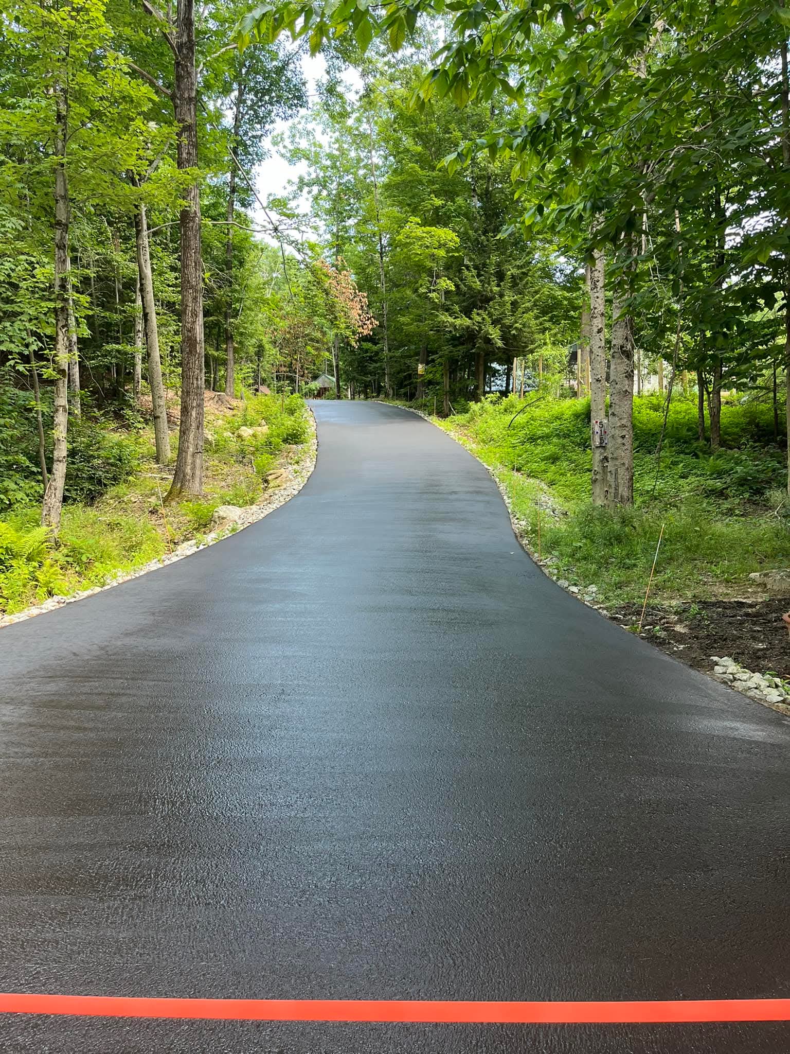 Long winding wooded driveway, fresh sealcoat top to bottom, deep black finish