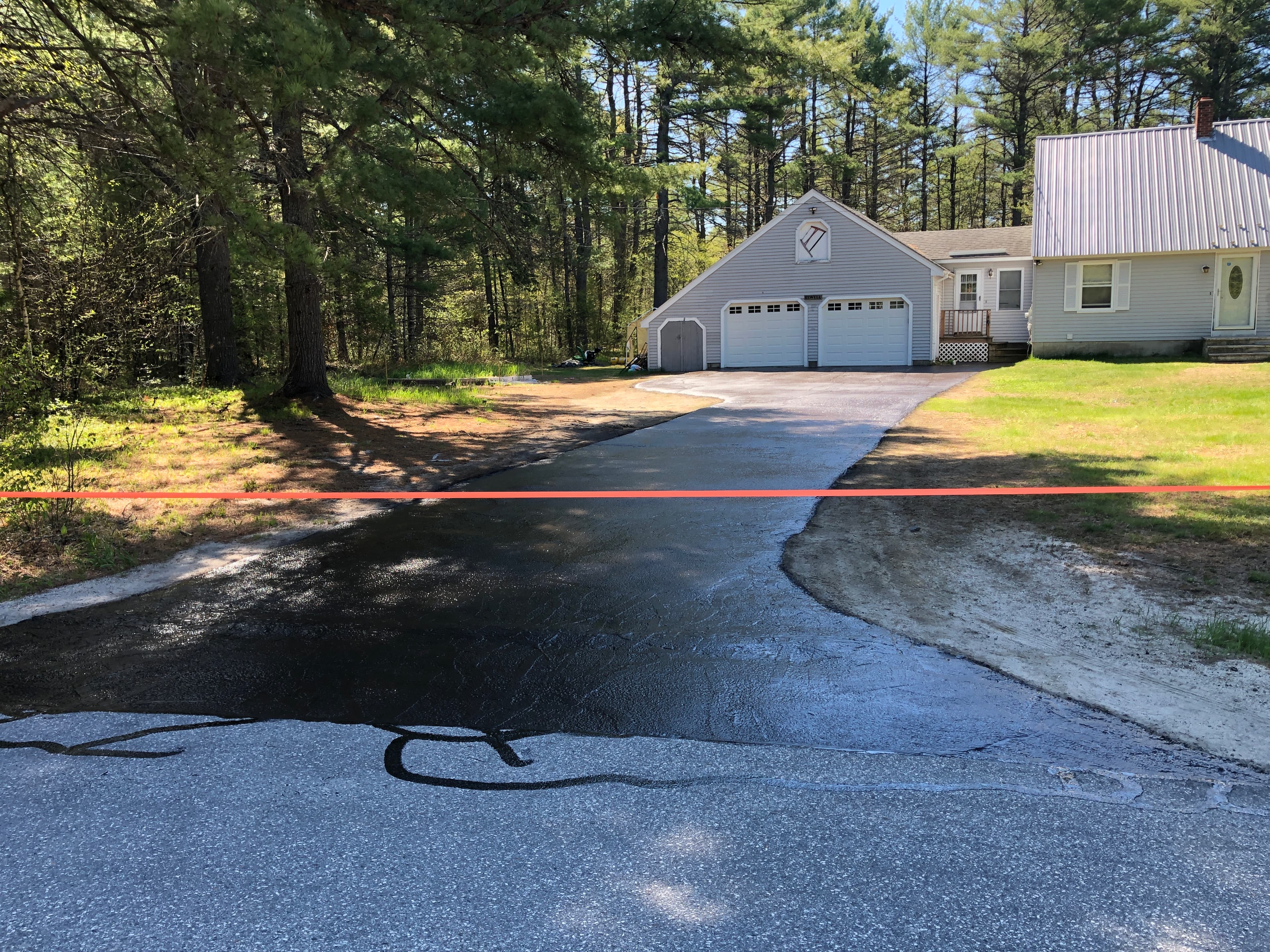 Split-entry home with freshly sealed concrete-edged driveway, tight, clean lines